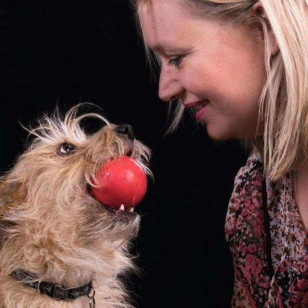 caroline mitchell and her terrier wilma face to face while wilma holds a ball
