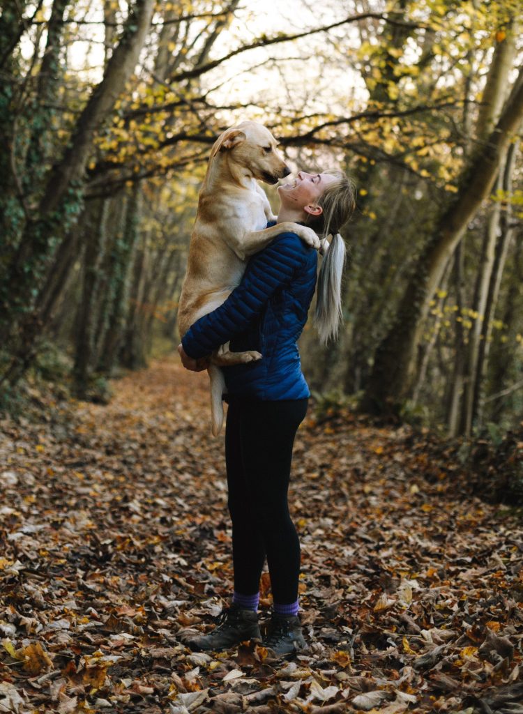 Young woman holding her dog in her arms for a cuddle