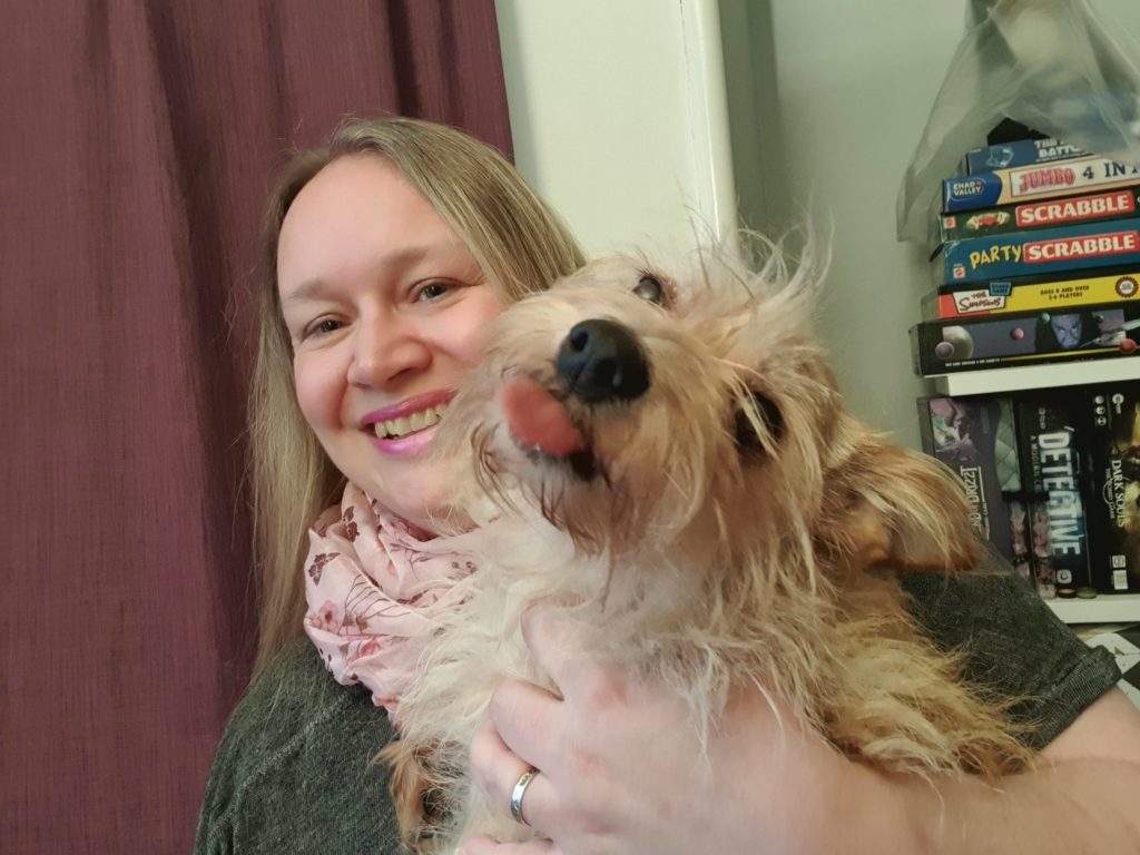 Terrier being held by Caroline, the dog has her tongue out